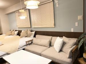 a living room with a couch and a table at TOMMY CONDOMINIUM WAKASA 401 in Naha