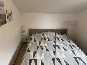 ein kleines Schlafzimmer mit einem Bett mit einem Scheppermuster in der Unterkunft Westerhuisje in Middelkerke