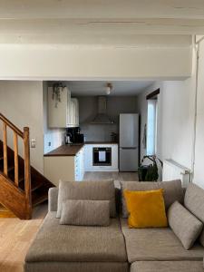 ein Wohnzimmer mit einem Sofa und einer Küche in der Unterkunft La maison du Gardien - LE PRIEURÉ DU PREUX 