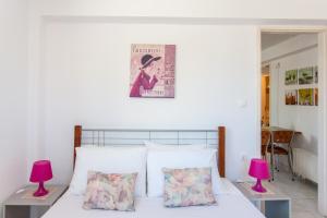 a bedroom with a bed with two pink lamps at Joy apartment by the sea in Rethymno