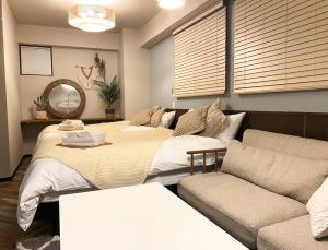 a living room with two beds and a couch at TOMMY CONDOMINIUM WAKASA 401 in Naha