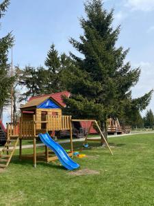 une aire de jeux avec un toboggan et une maison de jeux dans l'établissement Domek Sudecki Karłów, à Karłów