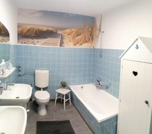 La salle de bains est pourvue d'une baignoire, de toilettes et d'un lavabo. dans l'établissement Ferienwohnung Mühlennest, à Emden