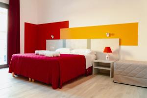 a bedroom with two beds with red and yellow at 16Miglia in La Caletta