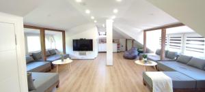 a living room with two blue couches and a tv at Villa Greenfield in Sarajevo