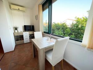 a dining room with a table and chairs and a window at Apartments Near the sea Barbat in Barbat na Rabu