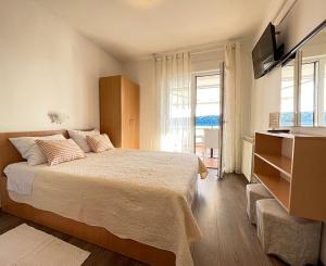 a bedroom with a large bed and a television at Apartments Near the sea Barbat in Barbat na Rabu