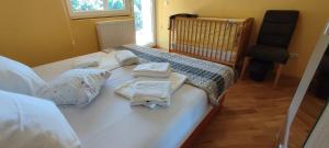 a bed with towels and a crib in a room at Villa Greenfield in Sarajevo +41 photos