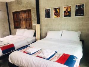 dwa łóżka siedzące obok siebie w pokoju w obiekcie SolarCell Private Homestay - โซล่าเซลล์ไพรเวทโฮมสเตย์ w mieście Uthai Thani