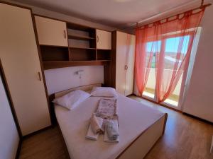 a bedroom with a bed and a large window at House MIRA in Barbat na Rabu