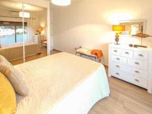 ein Schlafzimmer mit einem Bett und eine Kommode mit einem Spiegel in der Unterkunft Apartamento Gomes -Free Airco, wiffi & Swimming Pool- by bedzy in Porches