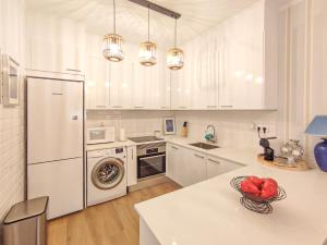 cocina blanca con nevera y lavavajillas en Apartamento Gomes -Free Airco, wiffi & Swimming Pool- by bedzy, en Porches