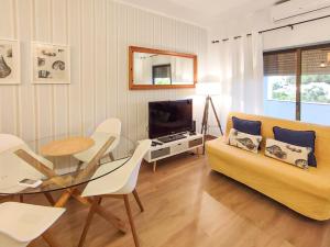 a living room with a couch and a table and a television at Apartamento Gomes -Free Airco, wiffi & Swimming Pool- by bedzy in Porches