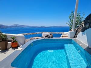 a swimming pool with a view of the water at Aqua & Terra Traditional Cave Houses in Oia