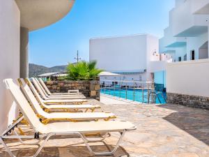 a row of lounge chairs on the side of a building at Elounda Alikes Suites & Studios in Elounda