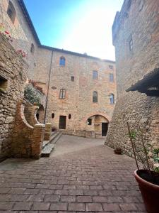 a large stone building with a brick courtyard at Castel Pietraio in Monteriggioni