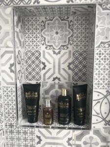 three bottles of essential oils on a shelf in a bathroom at Heart of Henley 1 & 2 Bedroom Apartments in Henley on Thames