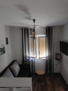 ein Wohnzimmer mit einem Sofa und einem Fenster in der Unterkunft Studio apartman Noa in Rijeka