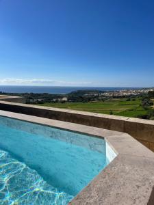a swimming pool with a view of the ocean at Villa dei Venti in Qala