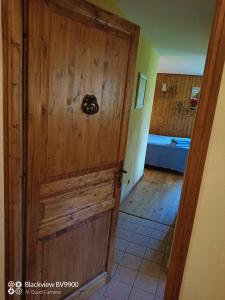 uma porta de madeira numa sala com um quarto em Chambre La Lavandula Col de Turini 