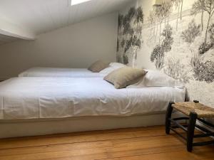 uma cama branca num quarto com um mural de parede em villa blanche Cabine 1 em Cap Ferret