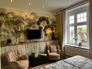ein Wohnzimmer mit 2 Stühlen und einem Flachbild-TV in der Unterkunft Gästehof Cafe im Schafstall in Barsinghausen