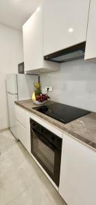 a kitchen with white cabinets and a bowl of fruit on the counter at Comfort Studio Bella Lucia in Portorož +12 photos