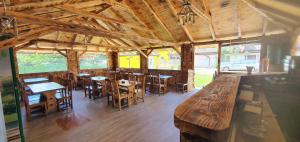 un restaurante con mesas y sillas de madera y ventanas en Complex Stefanesti, en Bozovici