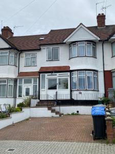a large white house with windows and a trash can at North West Lodge Guest House in London