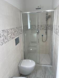 a white bathroom with a shower and a toilet at La perla del mare in La Caletta