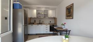 a kitchen with white cabinets and a table at Villa Greenfield in Sarajevo