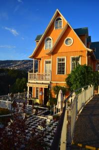 an orange house with a white fence in front of it at Hotel Brighton in Valparaíso