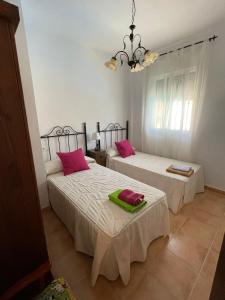 two beds in a room with pink pillows on them at Casa Lucía y Clara benaojan in Benaoján +16 photos