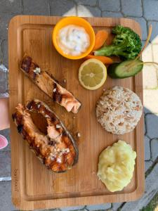 a wooden cutting board with seafood and vegetables on it at Yücel Hotel in Fethiye