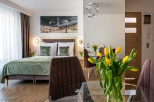 a bedroom with a bed and a table with chairs at InPoint Apartments G15 near Old Town & Kazimierz in Kraków