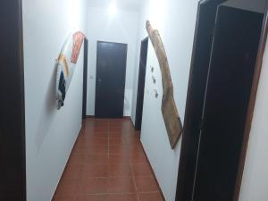 um corredor com quatro portas e piso em azulejo em Gota D'agua Guest House em Vila Nova de Milfontes