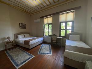 a bedroom with two beds and a couch and two windows at Oasis Hotel Edirne in Edirne