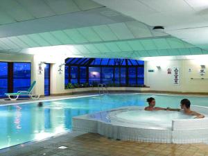 two people in a hot tub in a swimming pool at Best Western Palace Hotel & Casino in Douglas