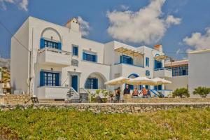 a large white building with blue windows at Aegean Sea in Lefkos Karpathou