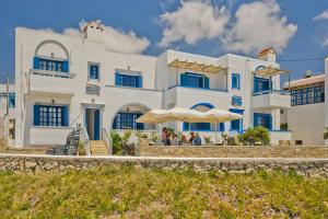 a large white building with umbrellas in front of it at Aegean Sea in Lefkos Karpathou