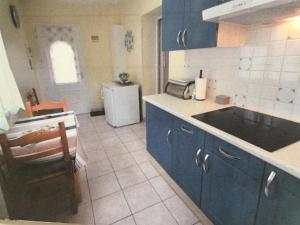 a kitchen with blue cabinets and a sink and a refrigerator at Gîte Moncherie in Colayrac-Saint-Cirq