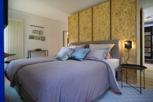 Un dormitorio con una cama grande con mantas y almohadas púrpuras. en RhönLoft - Ferienapartment, en Hünfeld