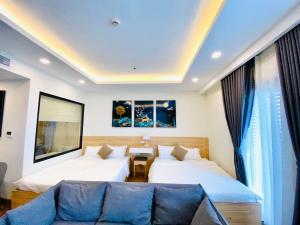 a hotel room with two beds and a couch at FLC SEA TOWER - Quy Nhơn in Quy Nhon +21 photos