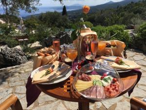 a table with food and glasses of wine at Boutique apart-hotel Galini, member of the best small hotels in Greece, Adults only in Volímai