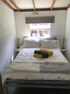 Pheasant Lodge في بيلث ويلز: سرير في غرفة مع وسادتين ونافذة