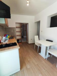 eine Küche mit einem weißen Tisch und einem weißen Tisch in der Unterkunft Apartment Batomalj in Baška