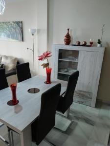 a dining room table with chairs and a vase with a flower at Ferrara playa in Torrox Costa