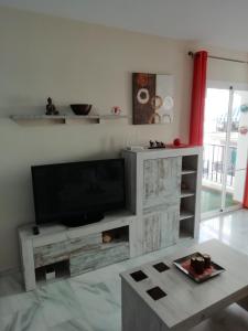 a living room with a flat screen tv on a wall at Ferrara playa in Torrox Costa