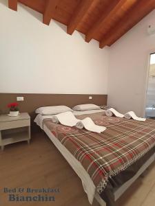 1 dormitorio con 1 cama grande y toallas. en B&B Bianchin via Trieste 67 Fiumicello-Villa Vicentina, en San António