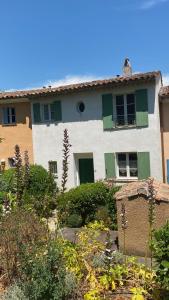 a white house with green shutters and a garden at Kleine Auszeit (Petite Pause) in Grimaud